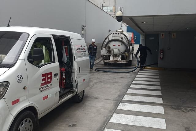 Camión de succión trabajando sobre un pozo en la vía pública
